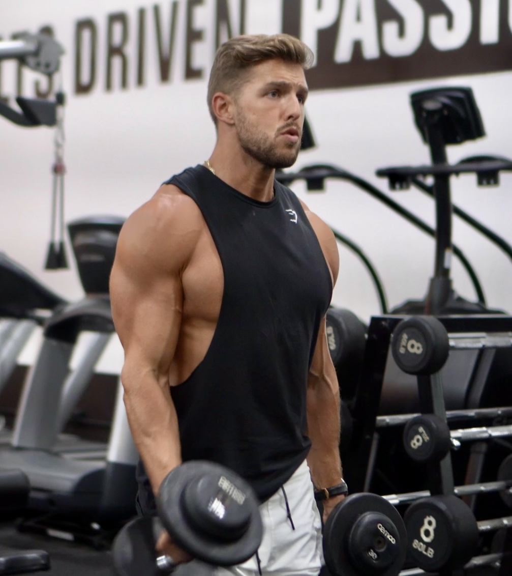 Anthony Perri holding dumbbells on the training floor in a Miami gym
