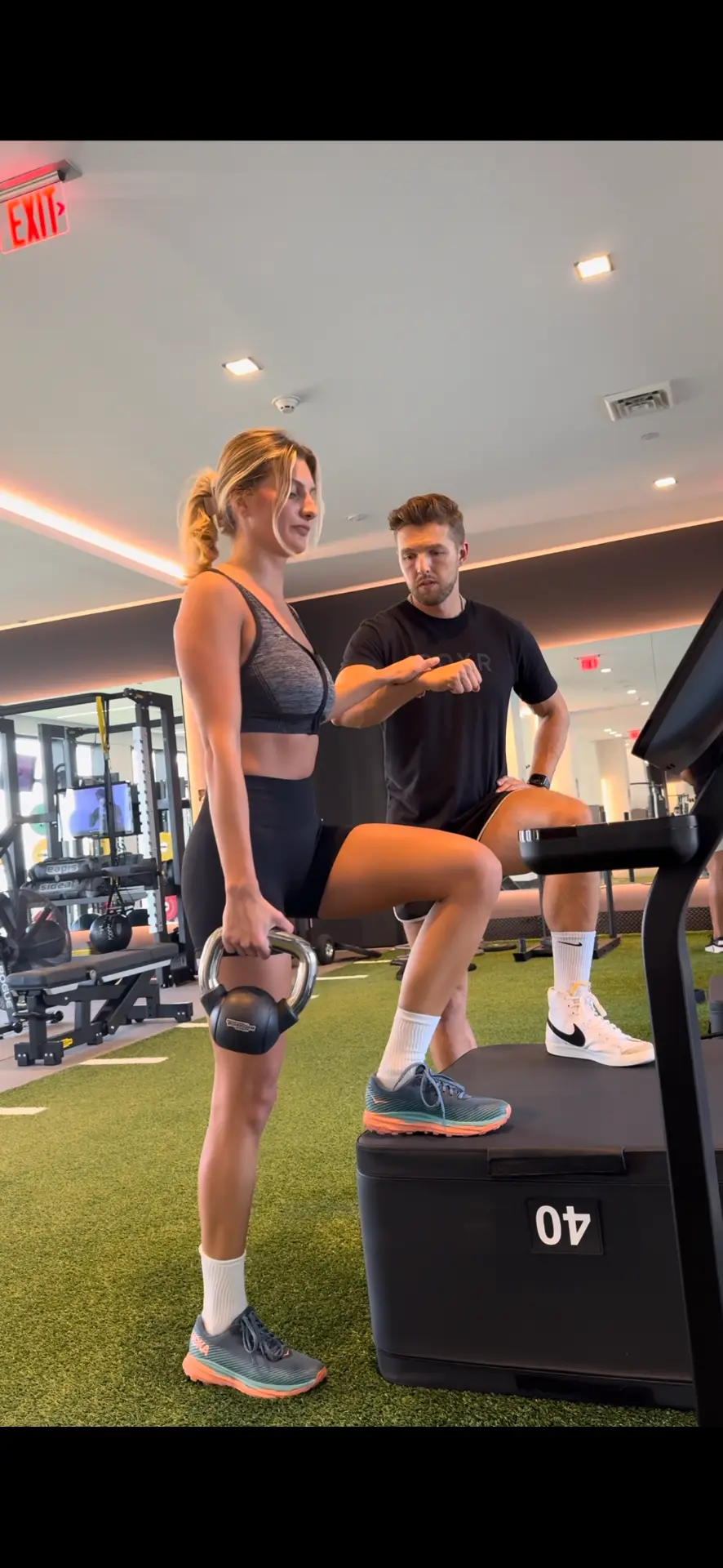 Anthony Perri coaching a client through kettlebell step-ups in a Miami gym